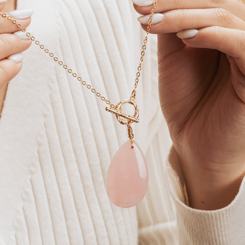 Woman holding pink palm necklace
