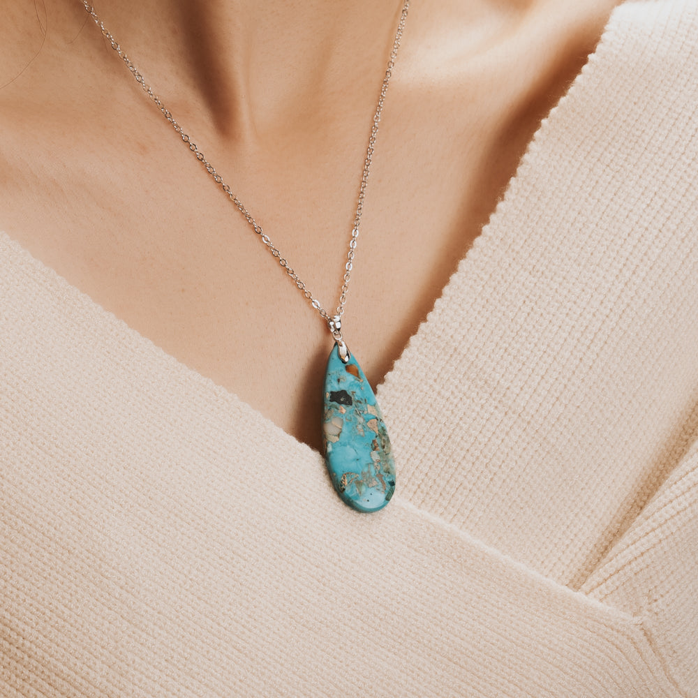 woman wearing teardrop pendant necklace