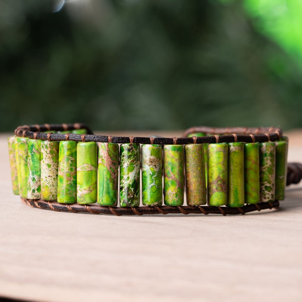 A refreshing and stylish leather wrap bracelet featuring tube-shaped cuts of dark green and naturally patterned Jasper stones