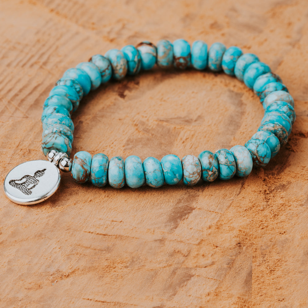 Treehut's stretchable bracelet with turquoise stone beads and a silver buddha charm in the center