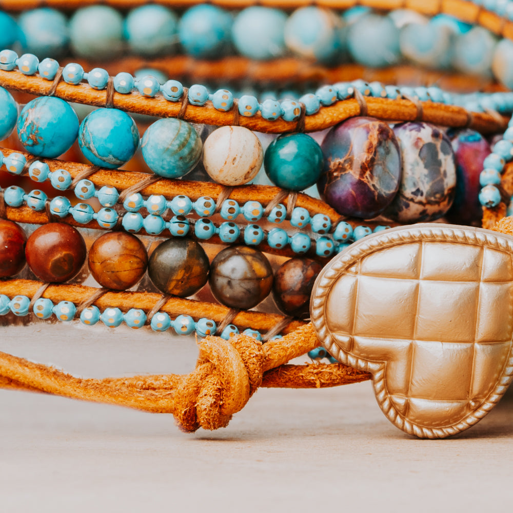 A three-wrap Treehut bracelet featuring gorgeous sea sediment jasper stones in shades of blue and purple.