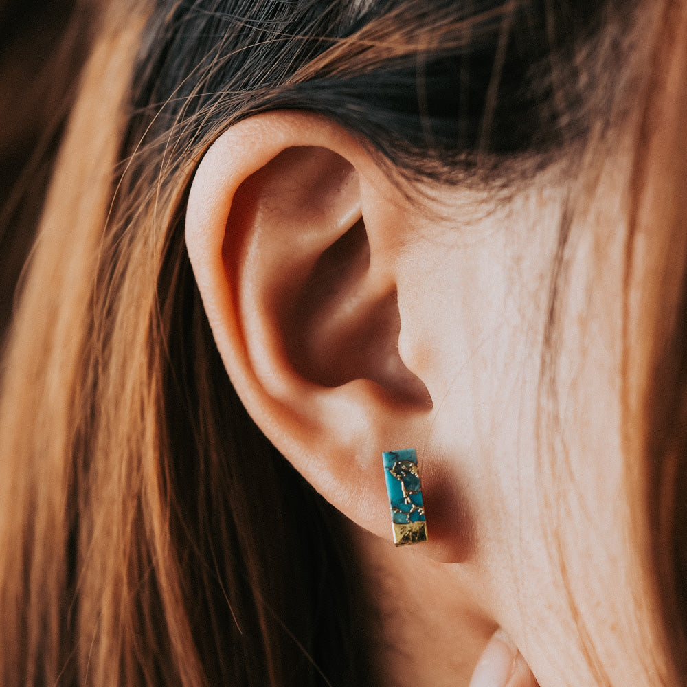 woman wearing turquoise stud earrings