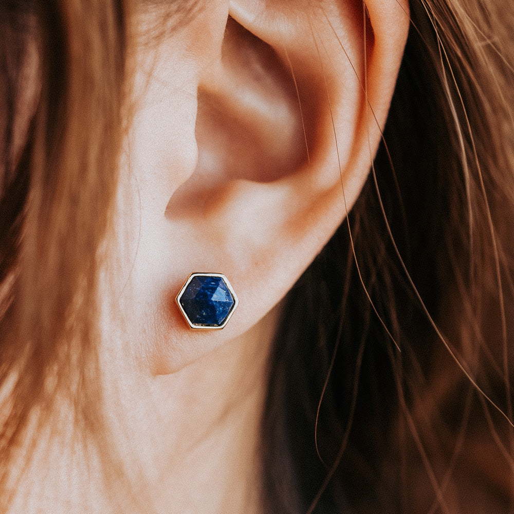 woman wearing blue stud earrings