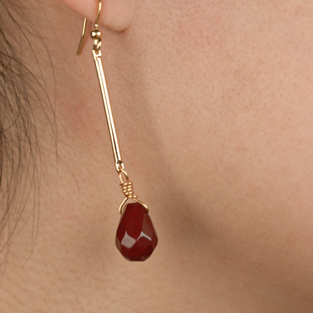 woman wearing red stone earrings