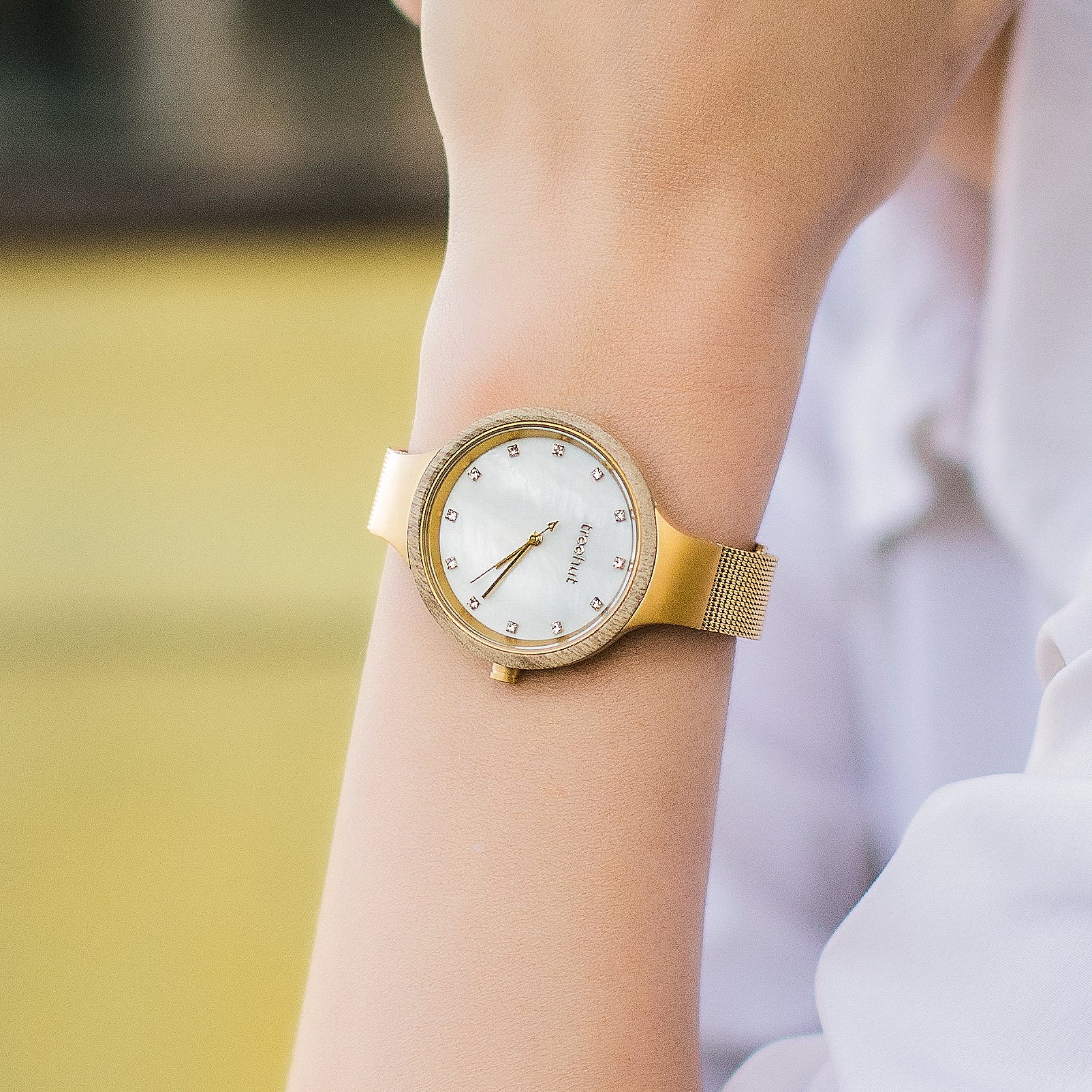 woman wearing gold pearl watch