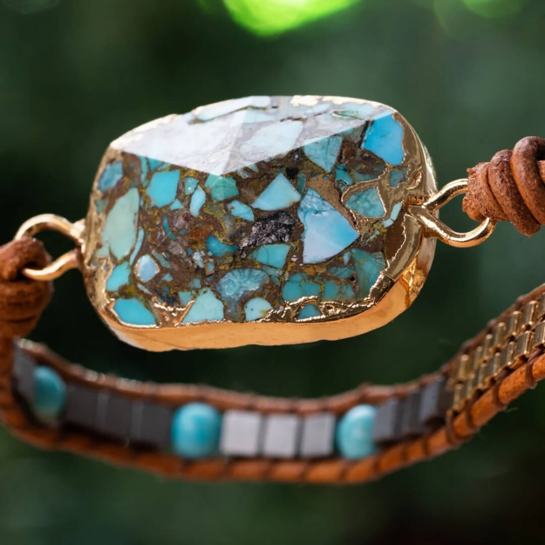 Triple-wrap leather bracelet with natural turquoise stone beads, a large centerpiece, gold bead nuggets, and silver beads. Adjustable between 19-21