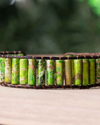 A refreshing and stylish leather wrap bracelet featuring tube-shaped cuts of dark green and naturally patterned Jasper stones