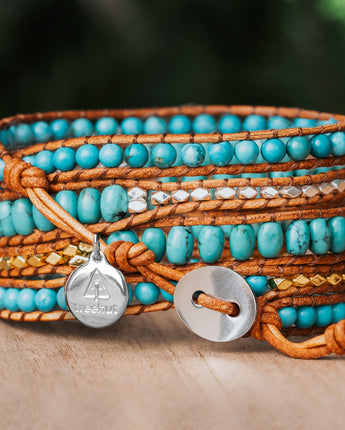 Add a touch of elegance to your outfit with this five-wrap bracelet, featuring natural Turquoise stone and Sterling Silver nuggets on earthy-toned leather